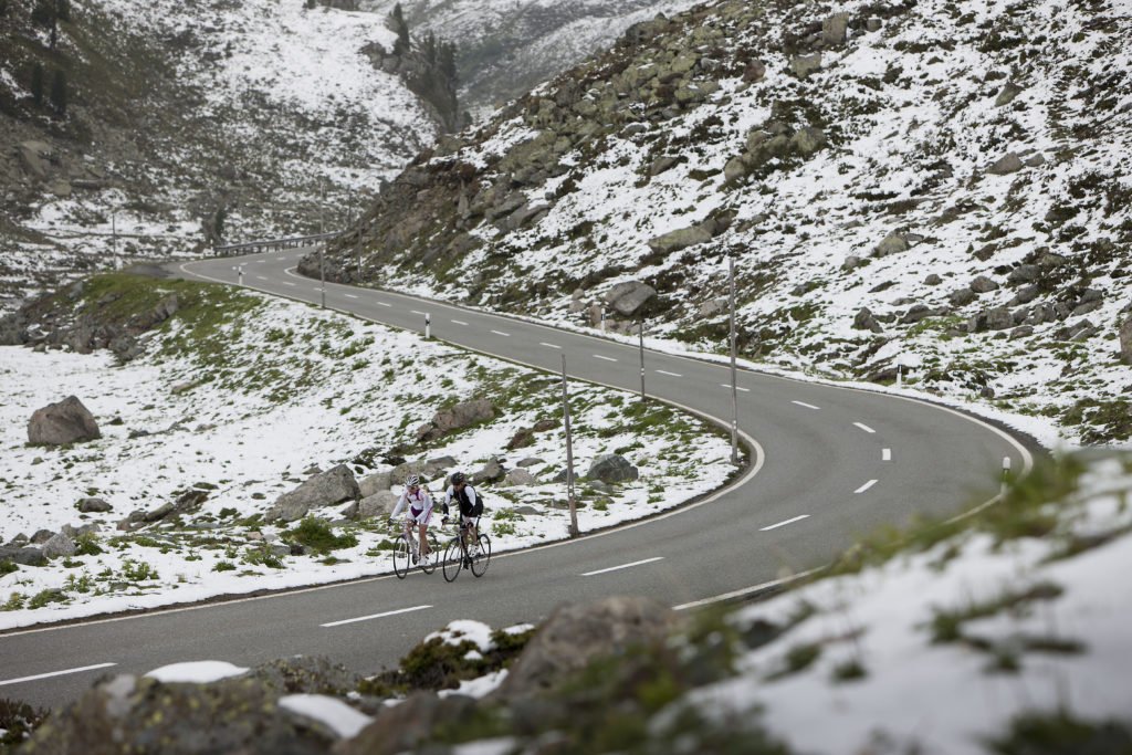 探索自行车爱好者的天堂——达沃斯-克洛斯特斯。骑自行车的人在雪山路上行驶。